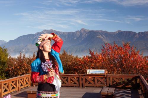 a woman holding a stuffed animal on top of a rail at Alishan Shermuh Tourist Hotel in Zhongzheng