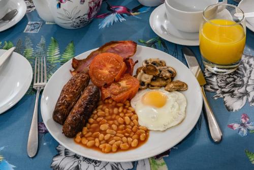 een bord ontbijtproducten met eieren, bonen en spek bij Bramble Lodge in Blakeney