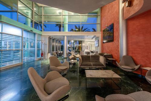 a lobby with chairs and tables in a building at Victoria Terme Hotel in Tivoli Terme