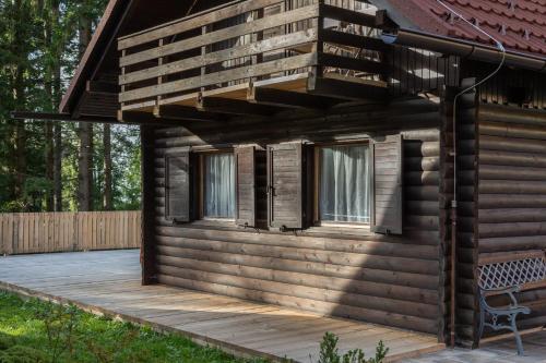 a log cabin with a deck and a balcony at Cabin Storzek in Pohorje