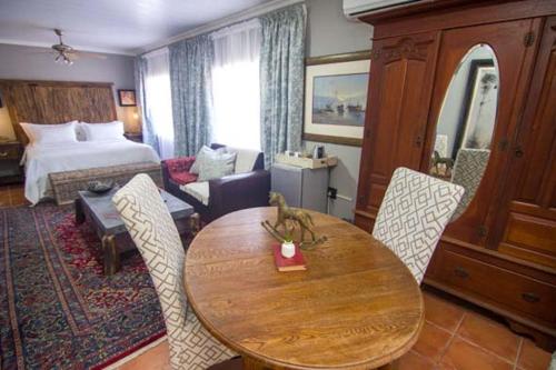 a hotel room with a table and a bedroom at The Place Guesthouse Parys in Parys