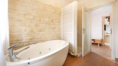 eine Badewanne im Bad mit einer Steinmauer in der Unterkunft Beautiful villa Benvenuti with private pool near Motovun in Motovun