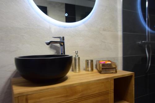 a bathroom with a black sink and a mirror at Les Terrasses de La Serre in Lascabanes
