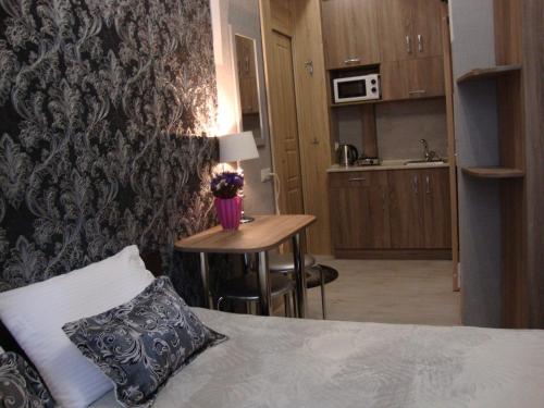 ein Schlafzimmer mit einem Bett und einem Tisch mit einem Kissen in der Unterkunft Апартаменты на ул.Шопена in Lwiw