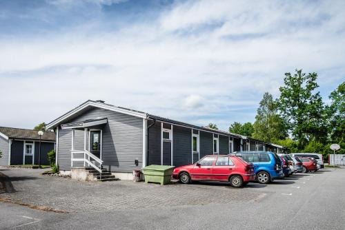 a group of cars parked in a parking lot next to a building at Halens Camping och Stugby in Olofström
