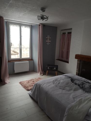 a bedroom with a bed and a large window at Joli appartement à Murat proche du Lioran Cantal in Murat