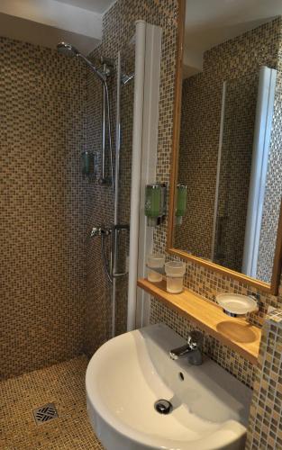 a bathroom with a sink and a shower and a mirror at Best Western Premier Montfleuri in Sainte-Maxime