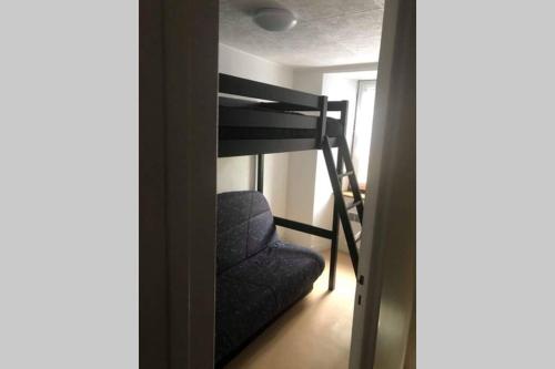 a room with a bunk bed and a chair at Joli appartement à Murat proche du Lioran Cantal in Murat