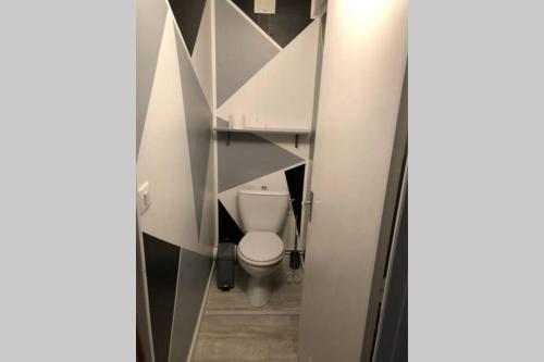a bathroom with a white toilet in a stall at Joli appartement à Murat proche du Lioran Cantal in Murat