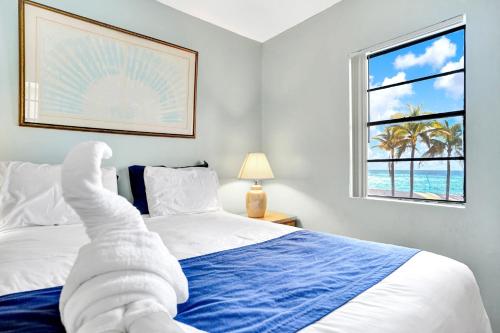 a bedroom with a bed with a towel laying on it at Neptune Oceanfront Rentals in Hollywood