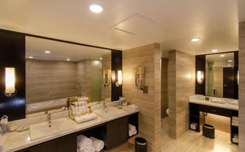 a bathroom with two sinks and a large mirror at Pan Pacific Sonargaon Dhaka in Dhaka