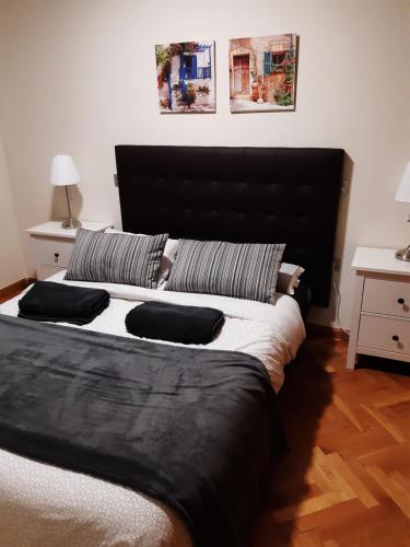 サラゴサにあるCasa Pedrada El Cosoの大型ベッド1台(黒いヘッドボード付)が備わるベッドルームです。