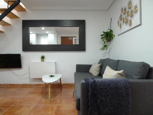 uma sala de estar com um sofá e um espelho em Apartment PALOMA em Madri