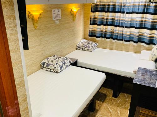 two white beds in a room with a window at Sleep Inn in Hong Kong