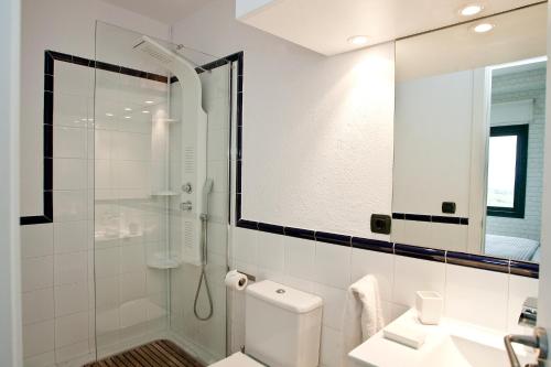 y baño con ducha, aseo y lavamanos. en Charming & Peaceful apartment Begur with Swimming pool, en Begur