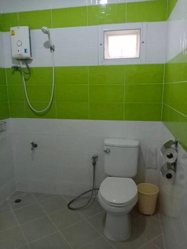 a green and white bathroom with a toilet and a shower at Chiangkham Grand Villa - SHA Certified in Chiang Kham