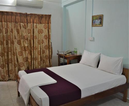 1 dormitorio con cama y cortina en Gnaanams Hotel and Restaurant en Jaffna