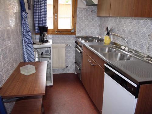 eine kleine Küche mit einer Spüle und einem Herd in der Unterkunft Pietra Serena 021 in Verbier