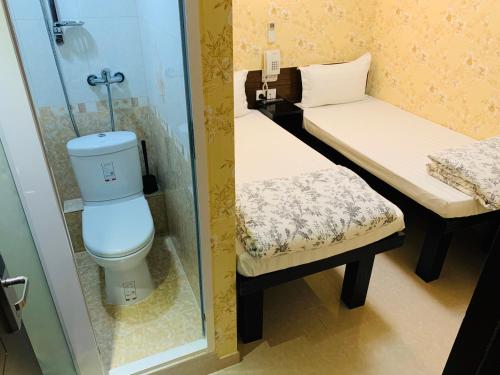 a small bathroom with a toilet and a shower at Sleep Inn in Hong Kong