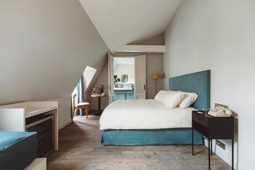 HOY Paris - Yoga Hotel في باريس: غرفة نوم مع سرير مع اللوح الأمامي الأزرق