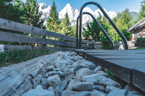 a walkway with rocks and a fence and mountains at Hiša Katja-Privat wellness in Kranjska Gora