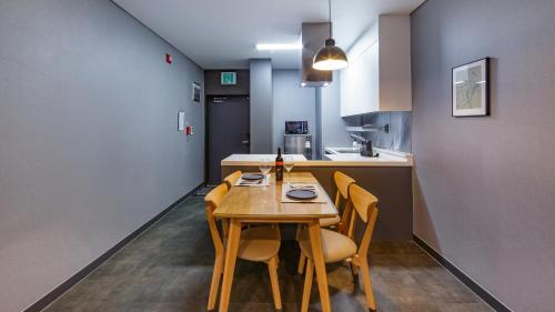 a small kitchen with a wooden table and chairs at Interlaken Stay in Gapyeong