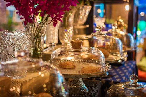 a table with plates of pastries in glass containers at Pro Andaman Place in Karon Beach