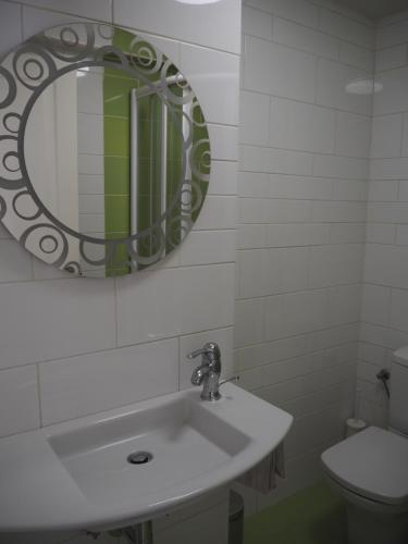 a bathroom with a sink and a mirror and a toilet at Apartamento El Ayuntamiento de Logroño in Logroño