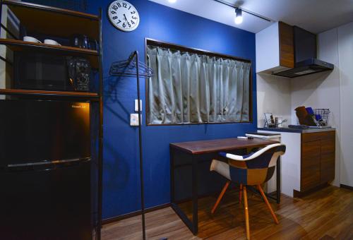 a kitchen with a blue wall with a table and a clock at 043AKIHABARA in Tokyo