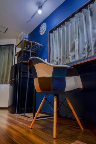 a chair in a room with a blue wall at 043AKIHABARA in Tokyo