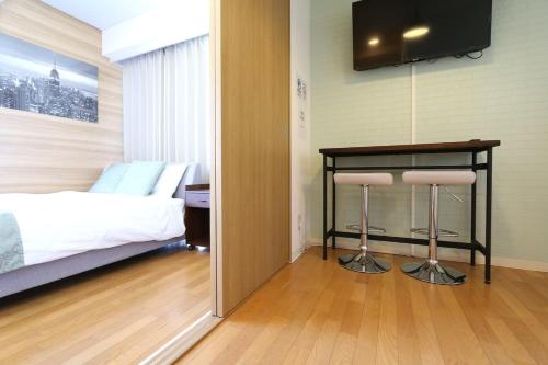 a bedroom with a bed and a table with two stools at NM61 Liz Osaka Castle in Osaka