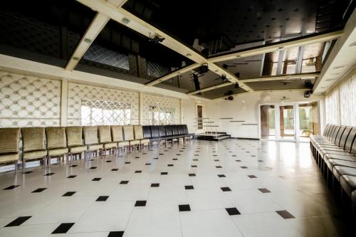 an empty room with rows of chairs in a building at Kamelot in Ternopilʼ