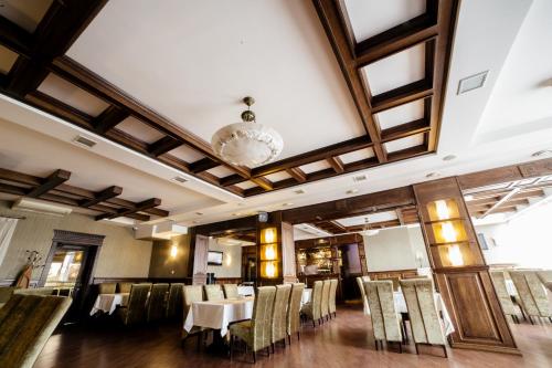 a dining room with tables and chairs and a chandelier at Kamelot in Ternopilʼ