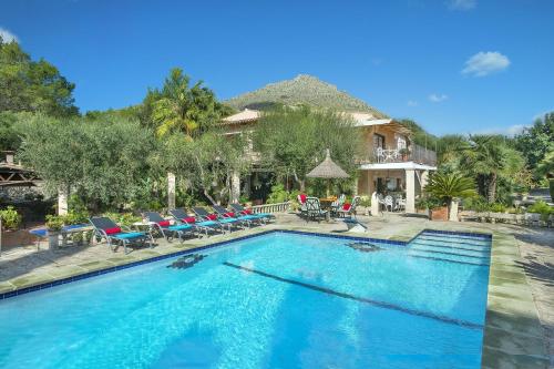 una piscina con sillas y una casa en Owl Booking Villa Far - 15 Min Walk to the Beach, en Puerto Pollensa