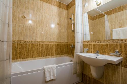 a bathroom with a sink and a bath tub and a sink at Aris Hotel Sofia in Sofia