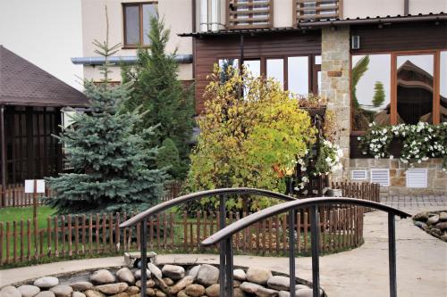 a home with a fountain in front of a house at Kamelot in Ternopilʼ
