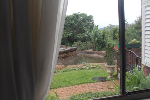 a view of a garden from a window at Le Residence de Josephine in Kloof