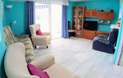 sala de estar con sofá y 2 sillas en Apartamento Orquídea, en Almuñécar