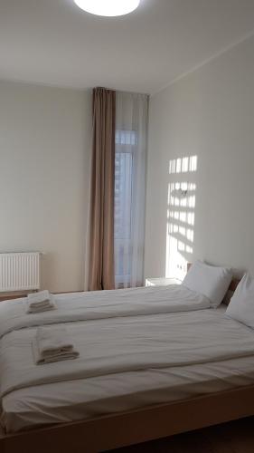 a large white bed in a bedroom with a window at Black Pearl Apartments in Jūrmala