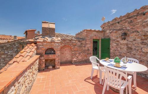 an outdoor patio with a table and chairs and an oven at La Ginestra - Terrazza in Orciatico