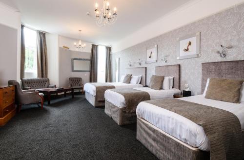 a hotel room with two beds and a chandelier at The Atholl Palace in Pitlochry