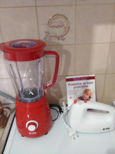Ein roter Mixer steht auf der Arbeitsfläche neben einem Toaster. in der Unterkunft Apartman KIKA in Sombor
