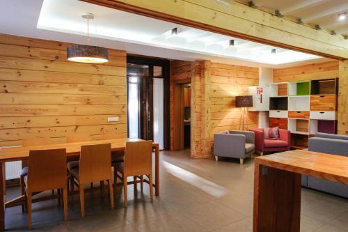 a dining room with wooden walls and a table and chairs at Трипільське Сонце in Podgortsy
