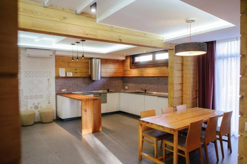 a kitchen with a wooden table and some chairs at Трипільське Сонце in Podgortsy