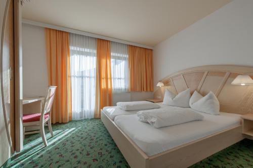 a hotel room with a large bed and a desk at Regina's Residenz in Sölden