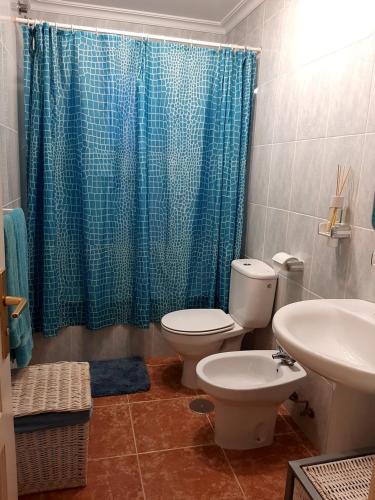 un bagno con un water e una tenda da doccia blu di Casa Luz a Costa Calma