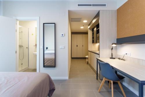um quarto com uma cama, uma secretária e uma casa de banho em Residencia Universitaria Campus Málaga em Málaga