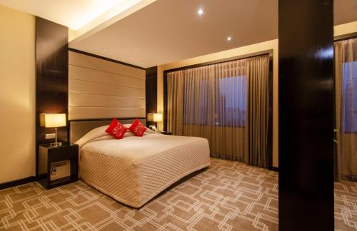 a bedroom with a large bed with red pillows at Pan Pacific Sonargaon Dhaka in Dhaka