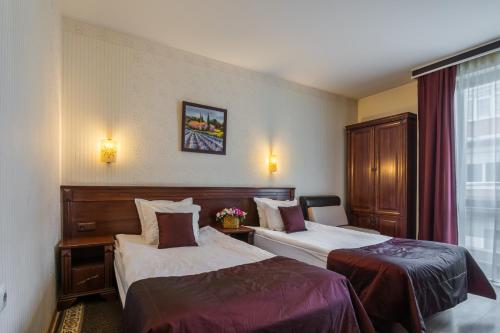 a hotel room with two beds and a window at Aris Hotel Sofia in Sofia