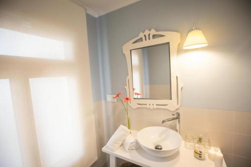a bathroom with a white sink and a mirror at El Patio de los Jazmines Boutique-House in Consuegra